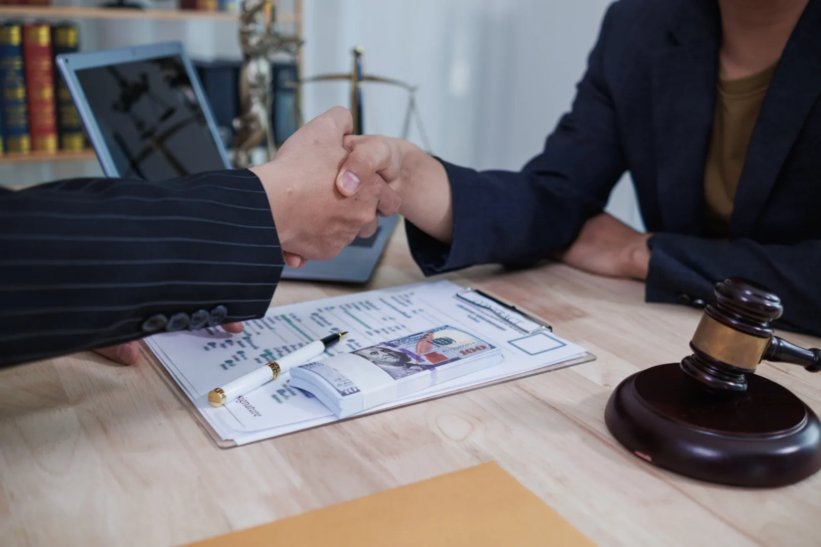 People shaking hands agreeing over case.